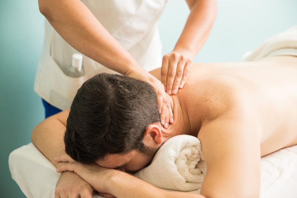 Massage in Multan – A professional therapist providing a relaxing neck and shoulder massage to a client at a wellness spa.
